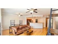 Bright living room with hardwood floors and ceiling fans leads to a kitchen with stainless steel appliances at 2700 Pine Tree Ne Rd # 3009, Atlanta, GA 30324