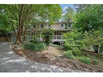 Charming two-story home with white trim, a front porch, and a stone walkway at 9480 Coleman Rd, Roswell, GA 30075