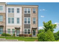 Charming two-story townhome featuring brick accents and a well-manicured lawn at 2631 Creekside Nw Dr, Atlanta, GA 30318