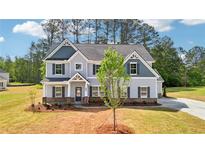 Charming two-story home featuring a gray color scheme and well-maintained landscaping at 3633 Squires Park Ln, Loganville, GA 30052