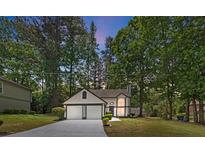 Charming two-story home featuring a two-car garage and landscaped front yard surrounded by mature trees at 5383 Biffle Way, Stone Mountain, GA 30088