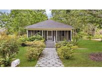 Charming home with a screened-in front porch and a landscaped front yard with a stone pathway at 204 Morris St, Palmetto, GA 30268
