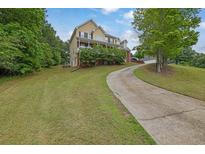 Inviting two-story home featuring a charming front porch and well-manicured lawn and a long driveway at 2530 River Run Dr, Dacula, GA 30019