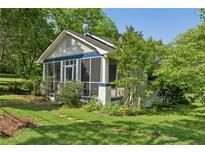 Charming home with a screened front porch, landscaped yard, and mature trees creating a welcoming curb appeal at 850 Fourth St, Stone Mountain, GA 30083