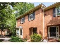 Charming brick townhome featuring a quaint arched entryway and well-manicured landscaping at 1341 Sheffield Glen Ne Way, Atlanta, GA 30329
