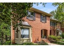Charming brick townhome with an arched entryway, manicured landscaping, and window shutters at 1341 Sheffield Glen Ne Way, Atlanta, GA 30329