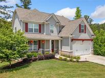 Charming two-story home with gray siding, red shutters, and a well-manicured lawn at 33 New Kent Ct, Villa Rica, GA 30180