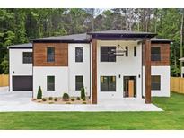 Stunning two-story home featuring a modern design with a combination of white brick and wood accents at 1349 Oak Road, Lilburn, GA 30047