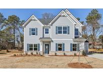 Charming two-story home with blue shutters and landscaped front yard, ready for new owners at 1462 Stephens View Dr, Loganville, GA 30052