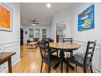 Bright dining area featuring hardwood floors, wainscoting, and an adjacent living room with comfortable leather seating at 1850 Cotillion Dr # 3215, Atlanta, GA 30338