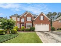 Beautiful two-story brick home with a well-manicured lawn and a two-car garage at 4045 Bonnett Creek Ln, Hoschton, GA 30548
