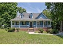 Charming home with a welcoming front porch, dormer windows and mature trees at 4002 Laurel Bend Dr, Snellville, GA 30039
