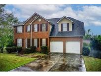 Charming two-story brick home featuring a two-car garage and a well-maintained front lawn at 2121 Silva Ct, Conley, GA 30288