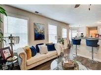 Bright living room featuring a modern sofa, stylish decor, and an adjacent kitchen with bar seating at 2121 Silva Ct, Conley, GA 30288