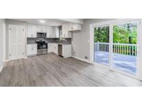 Bright, newly renovated kitchen with stainless steel appliances and white cabinets with access to an outdoor deck at 5857 Earlwane Dr, Lithonia, GA 30058