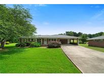 Charming single-story brick home with a well-manicured lawn and an attached covered carport at 87 Virgil Sw St, Mableton, GA 30126
