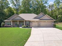 Charming brick home boasts a manicured lawn and a spacious driveway leading to a two-car garage at 150 Whitworth Dr, Locust Grove, GA 30248