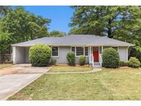 Charming single-story home with a well-maintained lawn, landscaped bushes, and a bright red front door at 1879 Rosewood Rd, Decatur, GA 30032