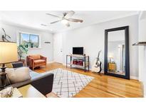Bright living room with hardwood floors, modern decor, ceiling fan, and large mirror creates a welcoming and stylish space at 228 Olympic Pl # 47, Decatur, GA 30030