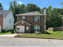 Charming two-story brick home with green shutters, a well-maintained lawn, and a one car garage at 3949 Riverside Pkwy, Decatur, GA 30034