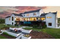 Stunning rear exterior showcasing a modern design with a built-in pool and a cozy fire pit area at 5160 Howard A Rd, Cumming, GA 30040