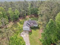 An aerial view of a charming home nestled in a lush forest setting at 2180 Briarwood Ct, Villa Rica, GA 30180