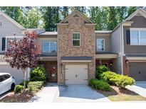 Charming townhome with brick facade, attached garage, and inviting front garden at 2534 Norwood Park Xing, Atlanta, GA 30340