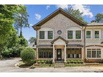 Charming brick townhome featuring manicured landscaping, stately pillars and decorative window accents at 3113 Lenox Ne Rd # 6, Atlanta, GA 30324