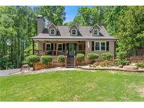 Charming home with a well-manicured lawn, inviting front porch, and mature trees at 2170 Jonquil Ct, Canton, GA 30115