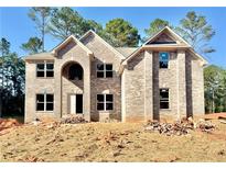 New two-story brick home featuring a symmetrical design, arched entry, and bright, spacious windows at 3018 Old Covington Rd, Covington, GA 30014