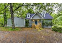 Charming home featuring light blue siding, dormer windows, and a welcoming front porch at 23 Club Dr, Locust Grove, GA 30248
