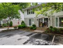 Charming townhouse with stone and siding exterior, parking in front, and mature trees at 136 Peachtree Memorial Nw Dr # Nh4, Atlanta, GA 30309
