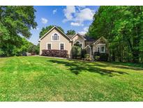 Charming home with a beautifully manicured front yard and mature trees at 1694 Peachcrest Ct, Lawrenceville, GA 30043