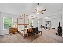 Spacious bedroom with a four-poster bed, ceiling fan, and workout equipment at 4814 Sultana Sw Way, Atlanta, GA 30331