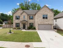 Charming two-story brick home featuring a well-manicured lawn and a two-car garage at 4814 Sultana Sw Way, Atlanta, GA 30331