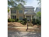 Charming two-story home featuring a stone facade, covered porch, and well-manicured landscaping at 4845 Backbay St, Suwanee, GA 30024