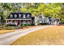 Charming home with dormer windows, inviting front porch, and long driveway leading to a detached garage at 965 Sundew Se Dr, Conyers, GA 30013