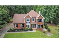 Charming two-story brick home with a well-manicured lawn and mature trees at 2482 Windchase Dr, Buford, GA 30518
