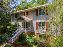 Charming home with red shutters, covered porch, and lush landscaping at 9041 Par Dr, Douglasville, GA 30134