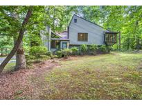 View of the house from the front yard surrounded by mature trees and landscaping at 1909 Winding Creek Sw Ln, Marietta, GA 30064