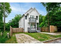 Charming two-story home with a white exterior, gray trim, small balconies, and well-kept lawn at 848 Fox Nw St, Atlanta, GA 30318