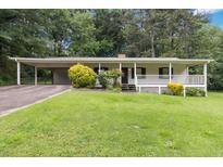 Charming one-story home with a carport, covered porch, and a well-manicured front yard at 1353 Litchfield Ct, Snellville, GA 30078
