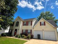 Charming two-story home with a two car garage and a well-maintained front yard at 130 Hazelhurst Dr, Covington, GA 30016