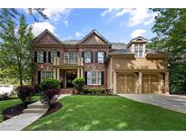 Beautiful brick home with a well-manicured lawn and attached two-car garage at 4840 Spring Park Cir, Suwanee, GA 30024