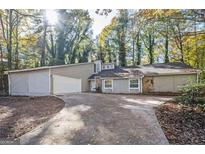 Charming one-story house with a garage, surrounded by lush trees at 5474 Post Road Pass, Stone Mountain, GA 30088