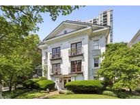 Elegant white building featuring balconies, framed by lush greenery and a well-manicured lawn at 1072 Piedmont Ne Ave # 101, Atlanta, GA 30309