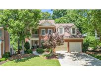 Charming two-story brick home with attached two-car garage and manicured front lawn at 1600 Heritage Trl, Roswell, GA 30075