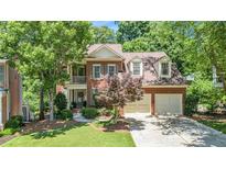 Charming two-story brick home with a well-manicured front yard and a two car garage at 1600 Heritage Trl, Roswell, GA 30075