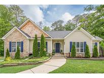 Charming home featuring a stone facade, manicured lawn, and a welcoming walkway, and eye-catching blue shutters at 188 Cooper Creek Dr, Dallas, GA 30157