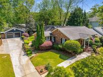 Charming brick home featuring mature landscaping, a detached garage, and a well-manicured lawn at 1041 Standard Ne Dr, Brookhaven, GA 30319